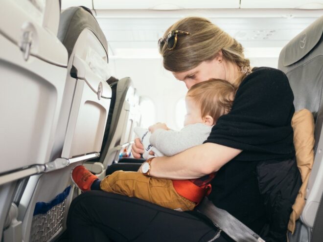 mom on plane with an infant using tips for flying with a baby