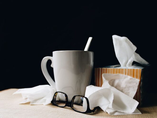 tissues tea and glasses on a table just missing essential oils for when you're sick