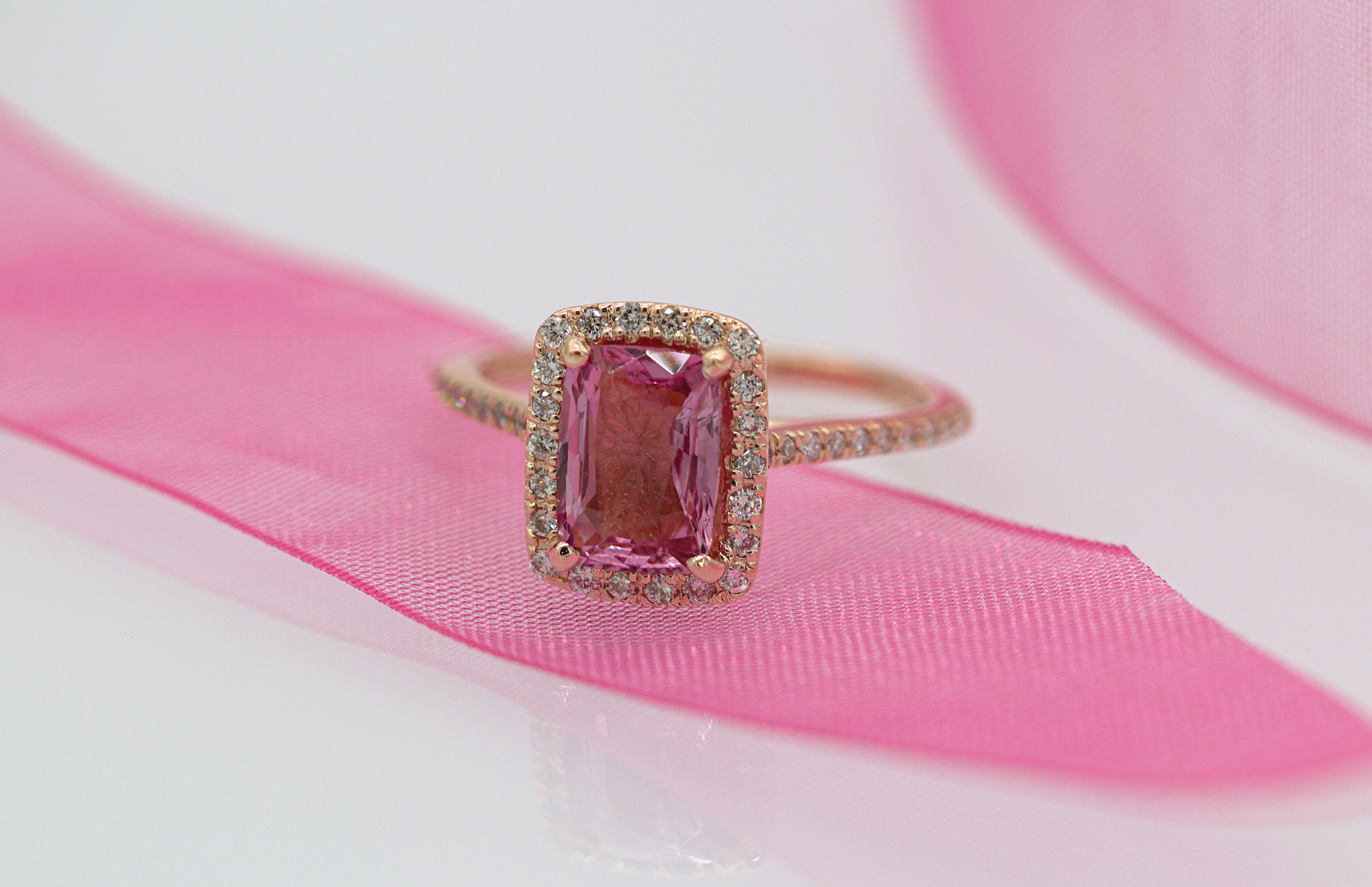 A ring with a pink rectangular, radiant cut stone.