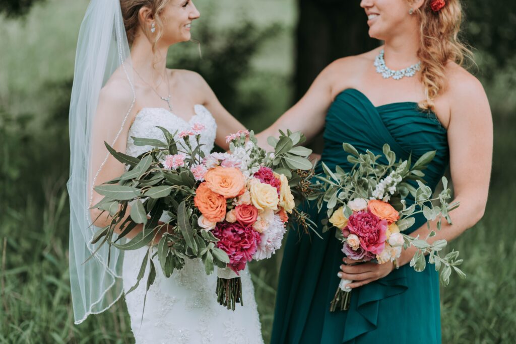 A bride and a bridesmaid hold bouquets.