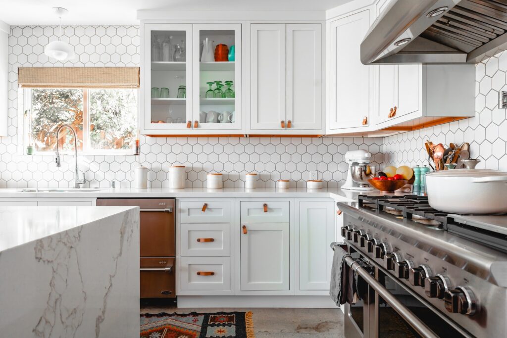 A kitchen with white, hexagon backsplash. 