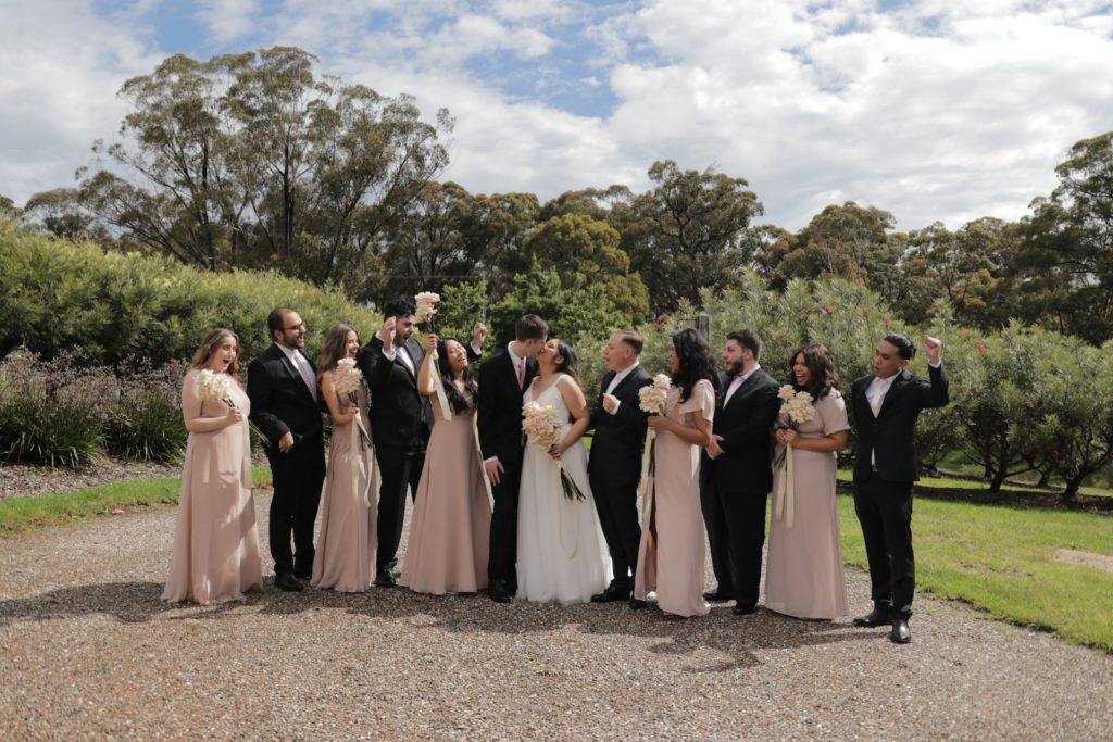 Bridesmaids and groomsmen surround a bride and groom.