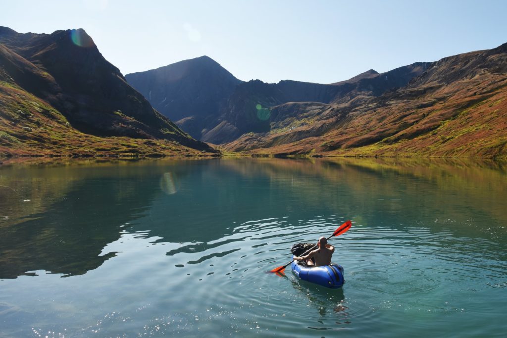 A man kayaks on a lake in Chugach State Park.