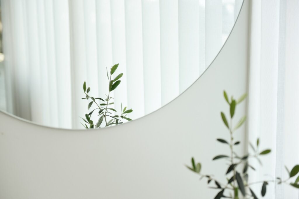 A round mirror hangs on a white wall.