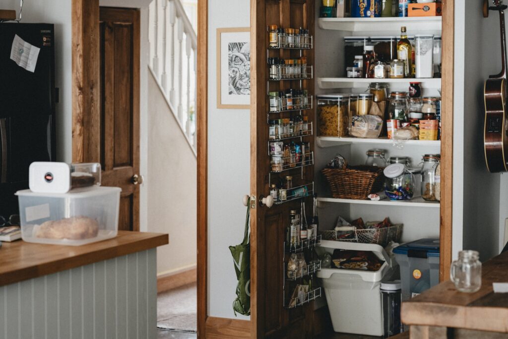 A kitchen pantry with an over-the-door spice rack.