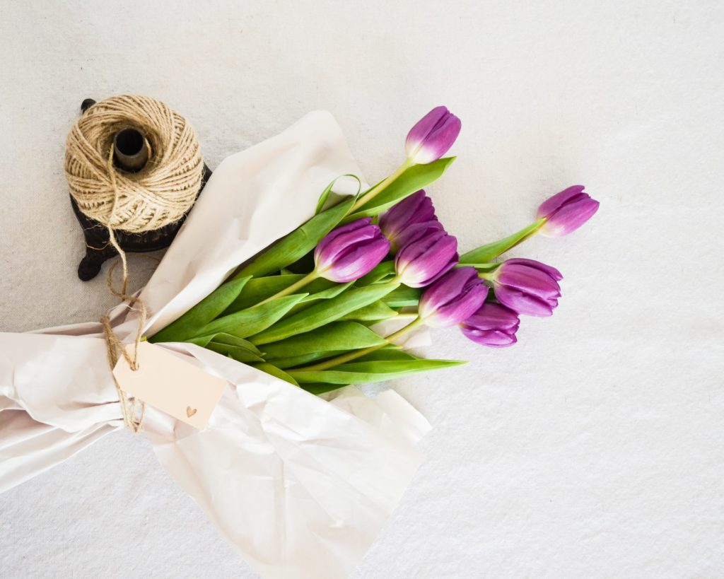 Purple tulips wrapped in white paper and twine.
