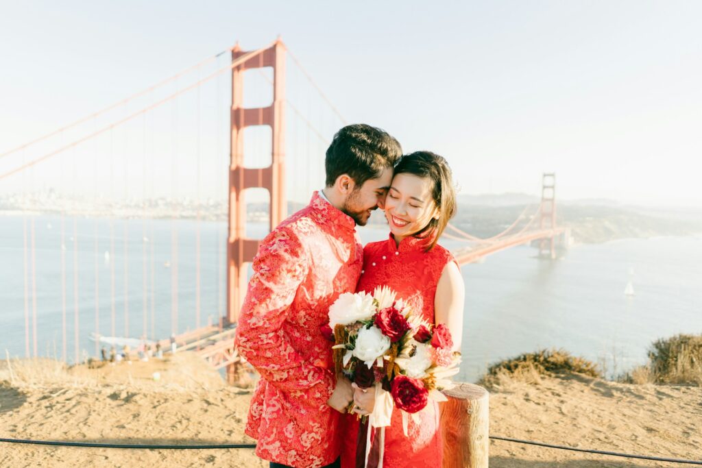 A bride and groom in front of the Golden Gate Bridge.
