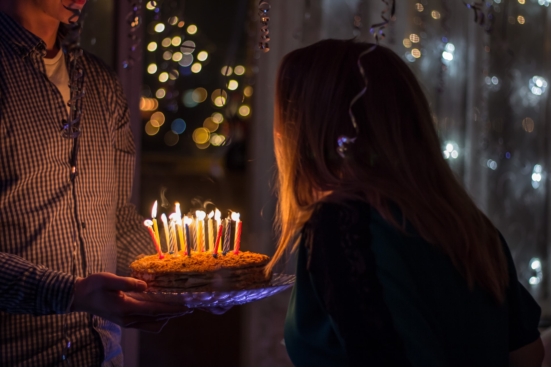 A woman blows out candles on a birthday cake.
