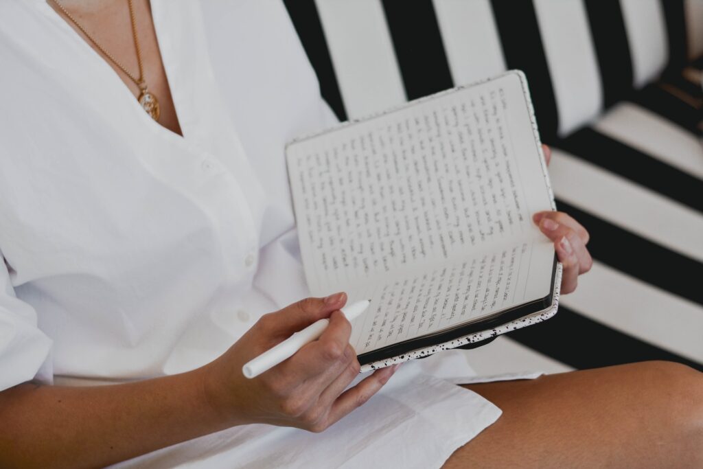 A woman writes in a journal. 