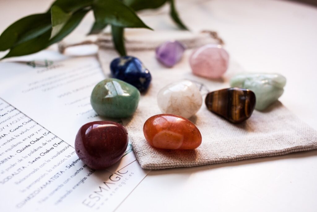 Different color stones sit on a table. 