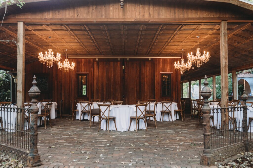 A barn wedding reception featuring chandeliers.
