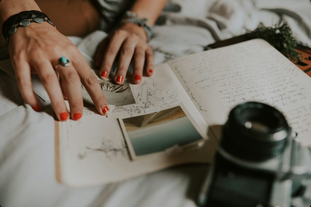 A woman tapes photos into a journal.