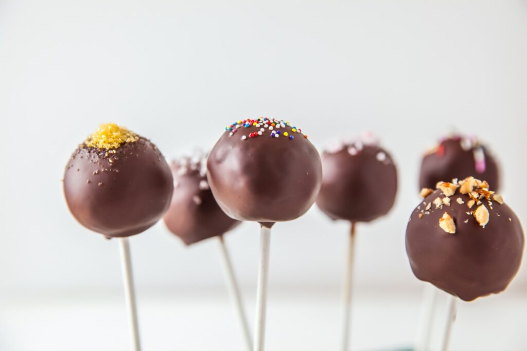 Cake pops covered in brown icing and sprinkles.