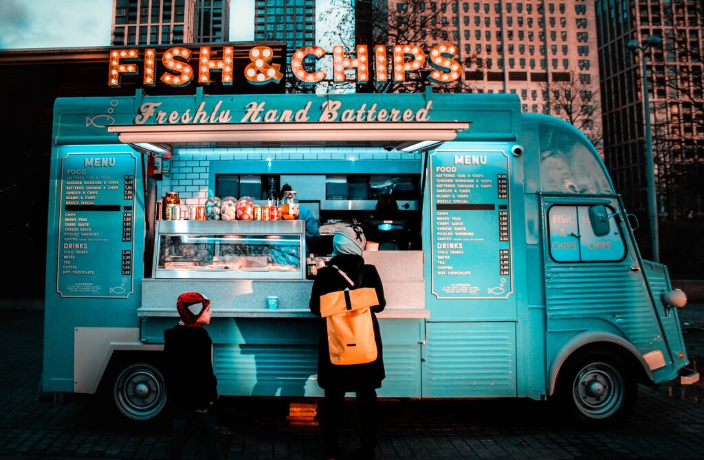 A person orders food at a fish and chips food truck.