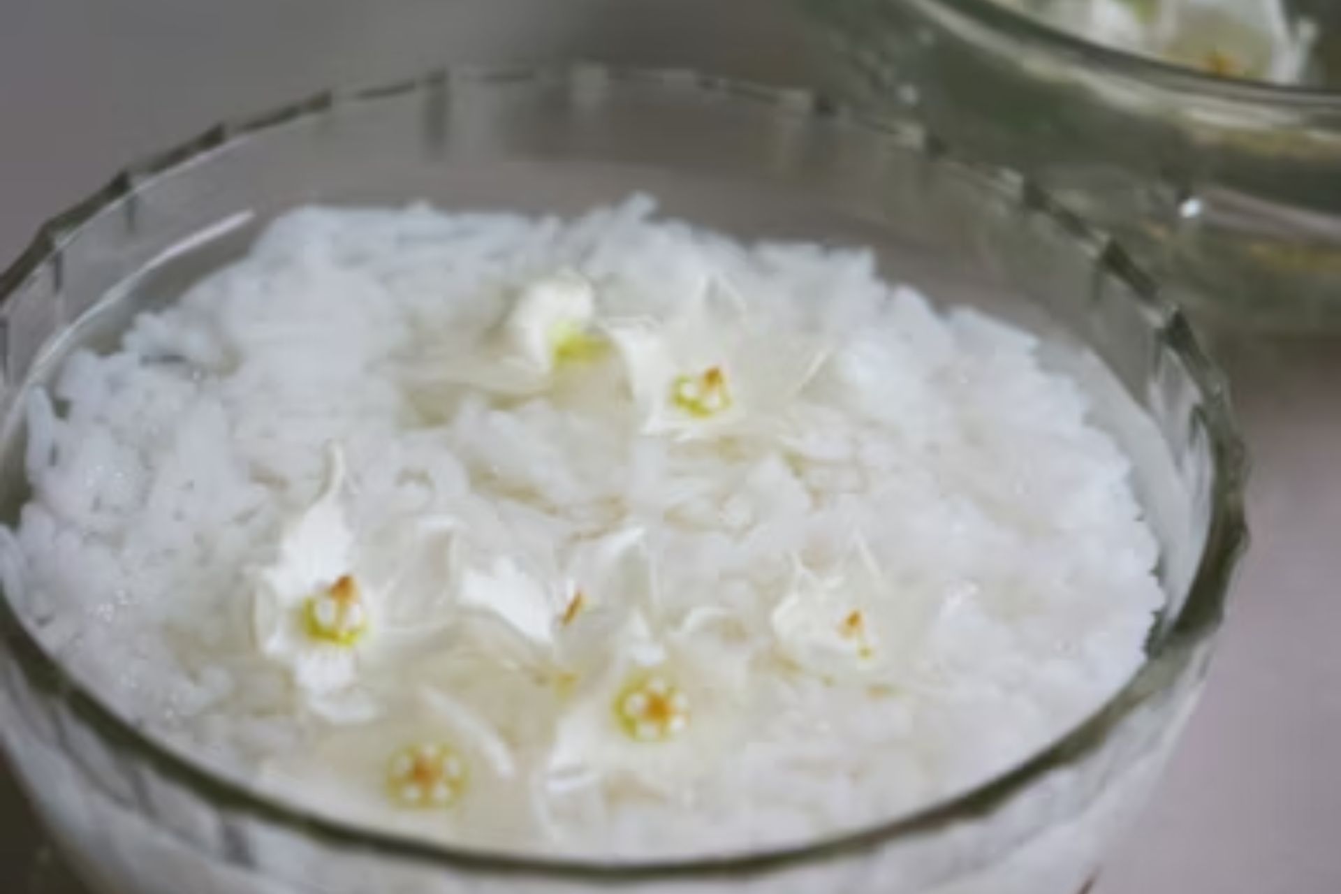 The image features a glass bowl of white rice, which is the perfect way to soak it and create rice water for skin.