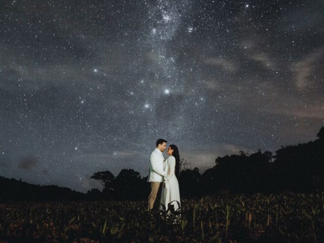 When you choose an Airbnb wedding, you can have a memorable backdrop like this one: a man and a woman wearing white amidst a starry night sky.