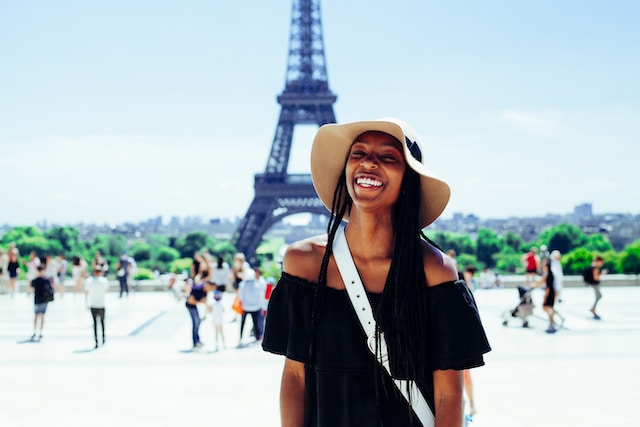 Woman smiling in front of the Eiffel Tower. 