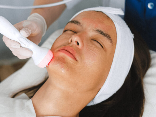 A woman being treated in the face using red light therapy