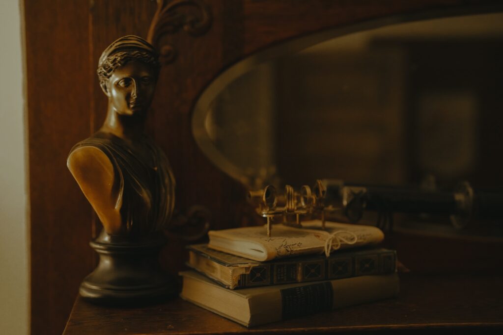 Books and a bronze bust sit on a mantle.