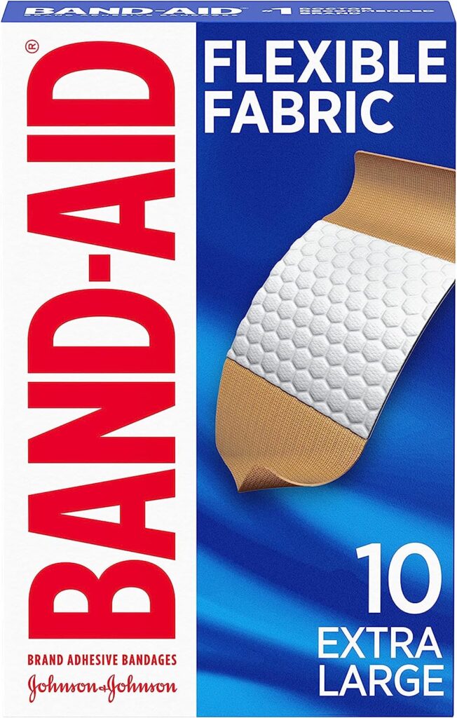 A blue and white box of Band-Aid flexible fabric extra large bandages sits against a white background.