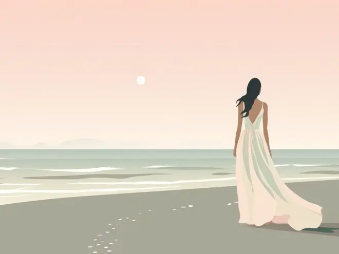 A bride wearing a flowy white gown walks on the beach.