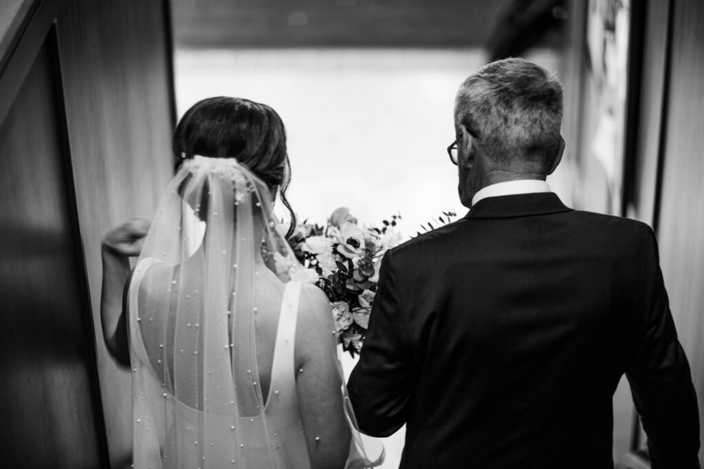 A bride and her father about to walk down the aisle. 