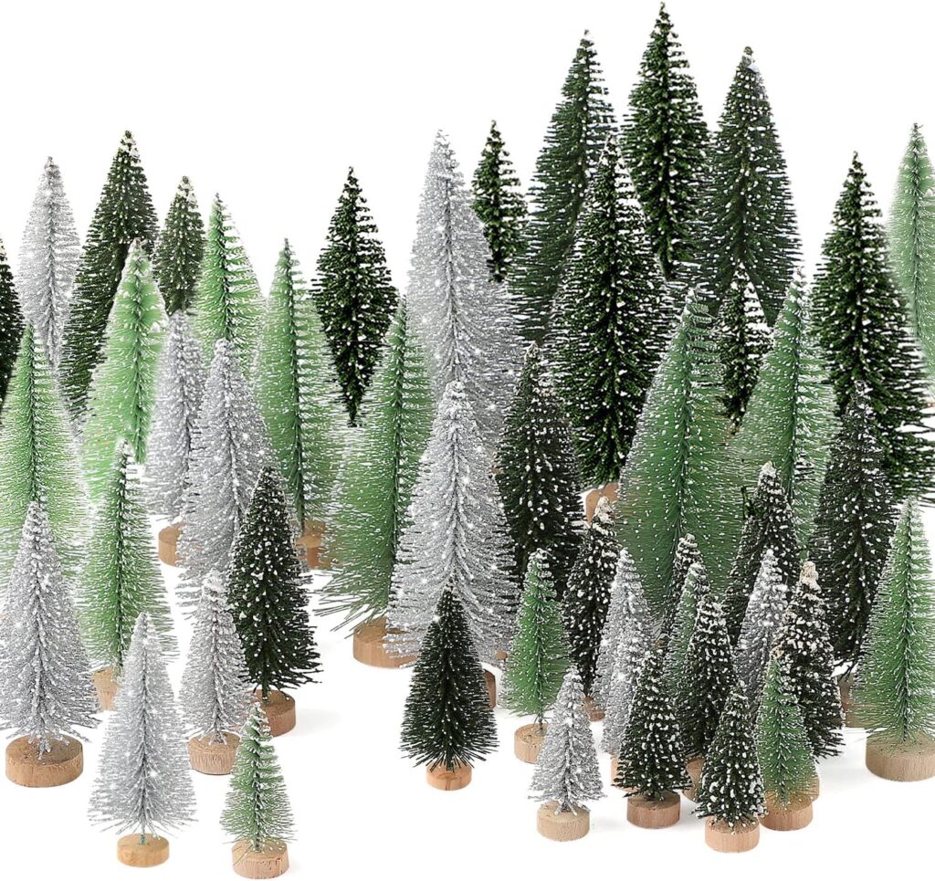 30 miniature pine trees covered in fake snow sit against a white background. They're all different sizes and different shades of green and gray. Each has a small round wooden base.