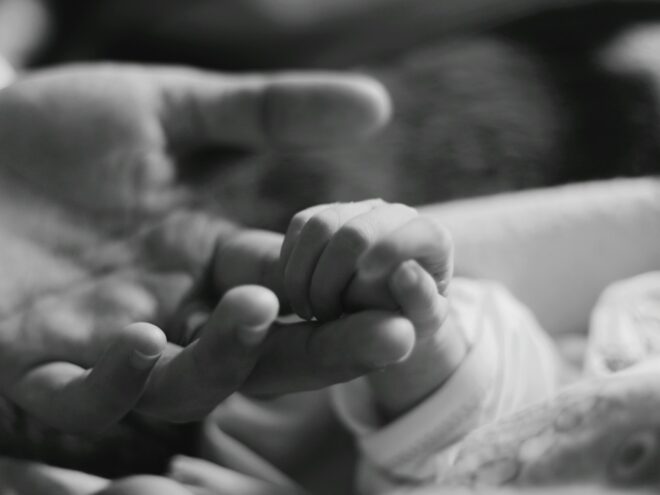 Baby holding mom's finger.