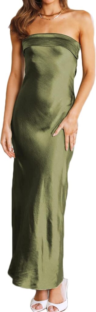 A woman stands in a green silk strapless dress that reaches teh floor.