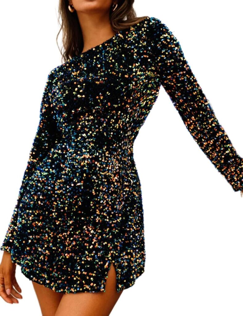 A woman stands in a thigh-length black velvet long-sleeved dress covered in sequins.