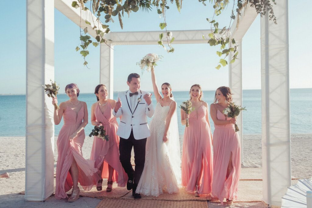 A bride, groom and bridesmaids at a beach wedding. 