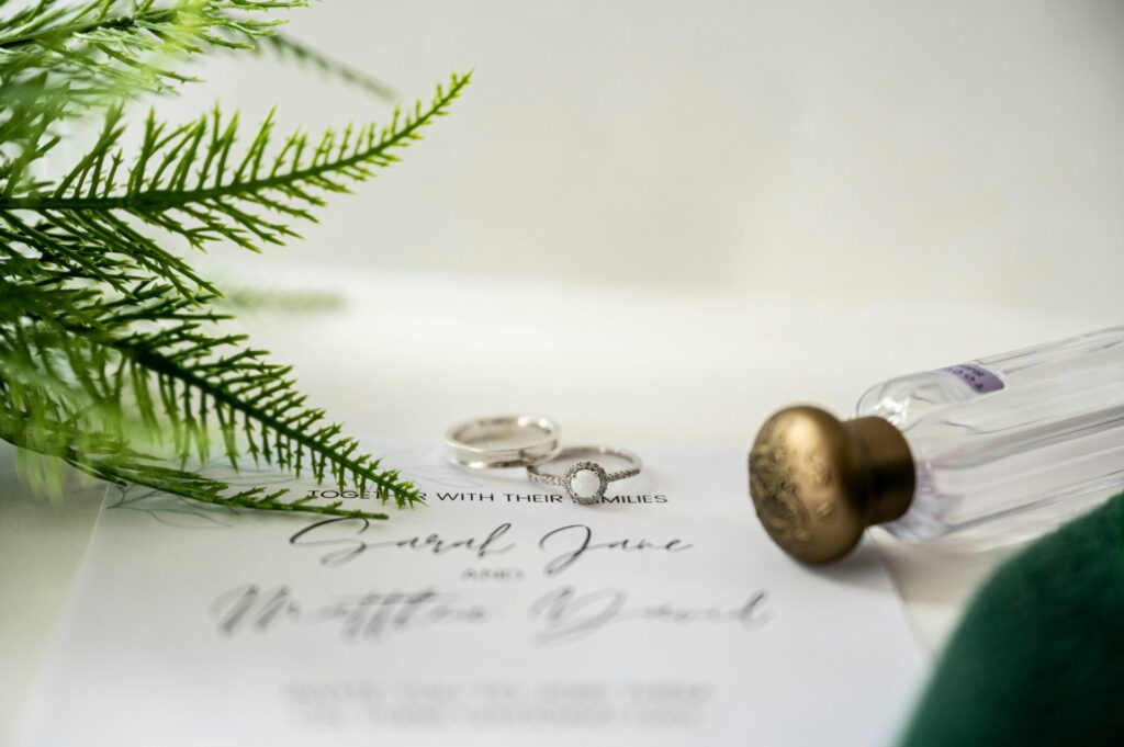 Wedding rings surrounded by green foliage.