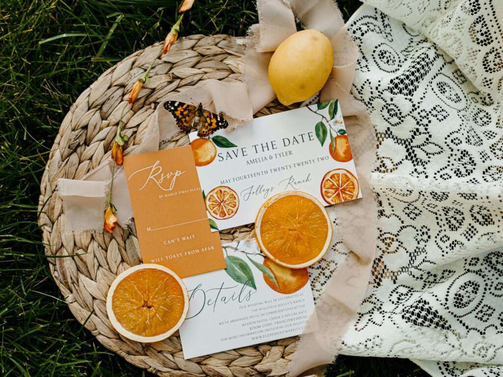 A save the date card with orange designs. 