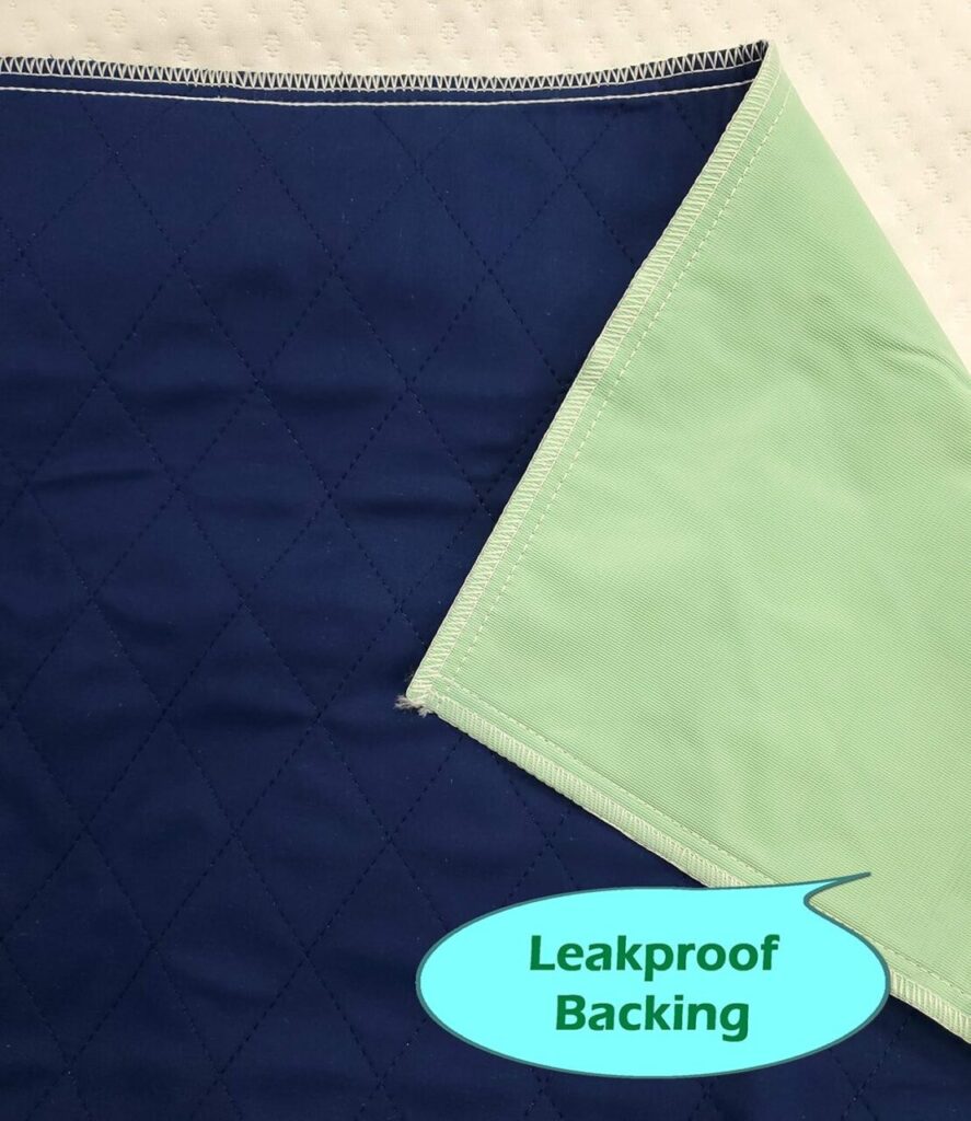 A navy and light green mattress protector sits against a cream colored mattress. One corner is pulled back to show the waterproof fabric.