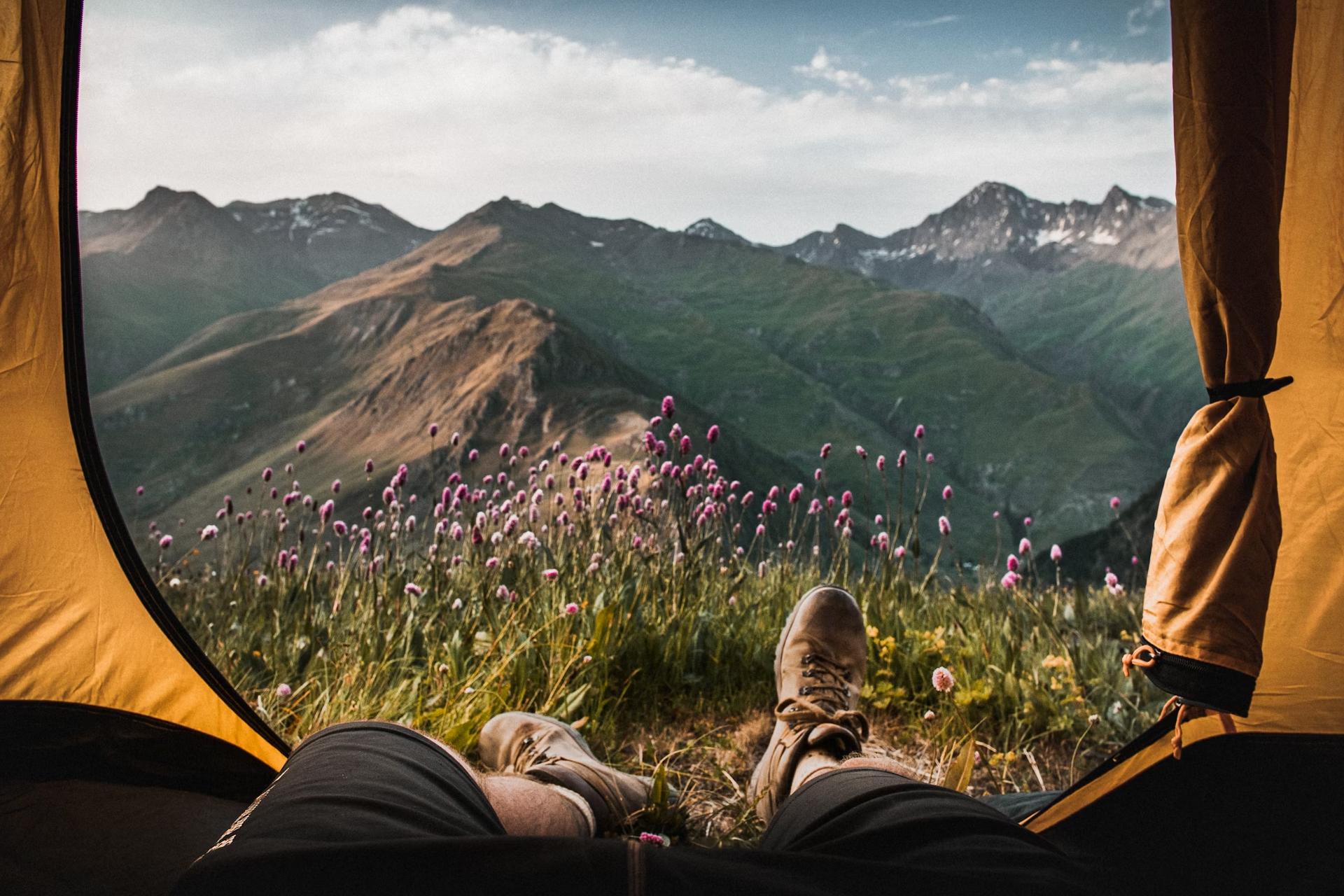 man in tent watching mountain