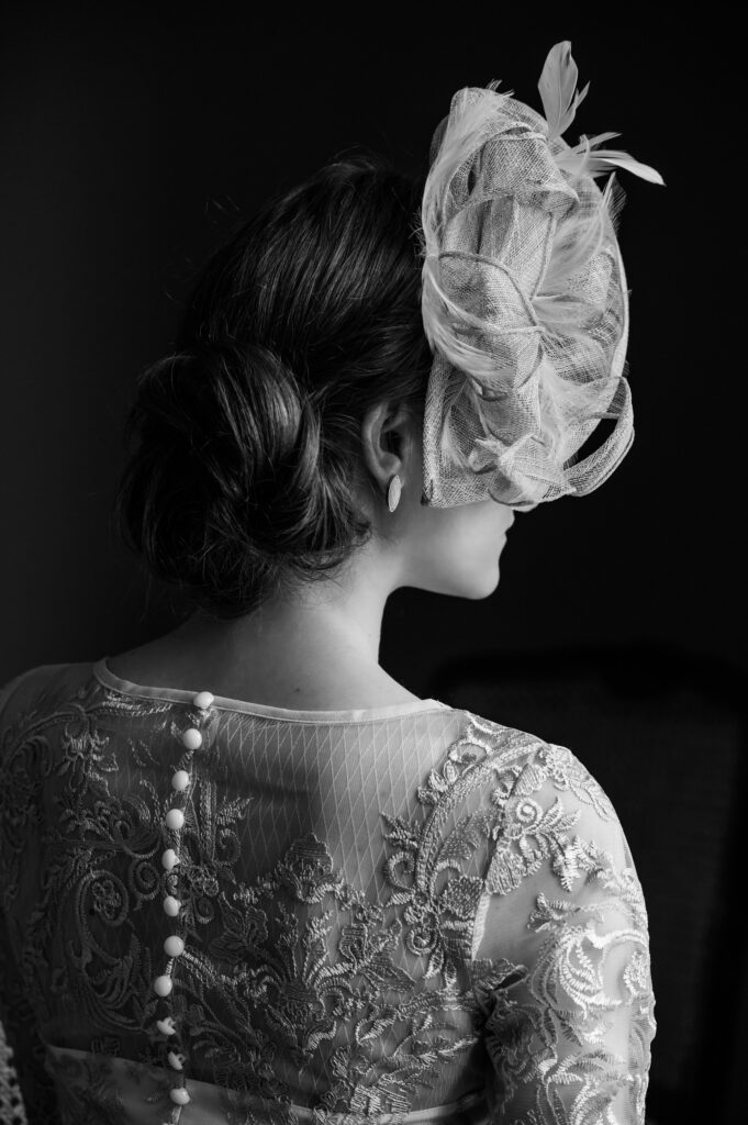 Grayscale images of a woman wearing a lace wedding dress and a feathered headpiece. 
