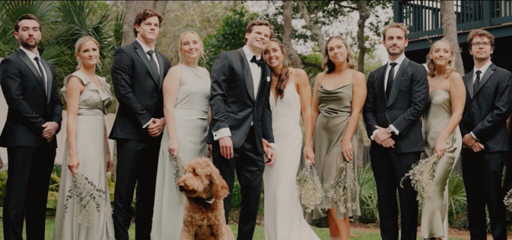 A dog poses with a bridal party. 