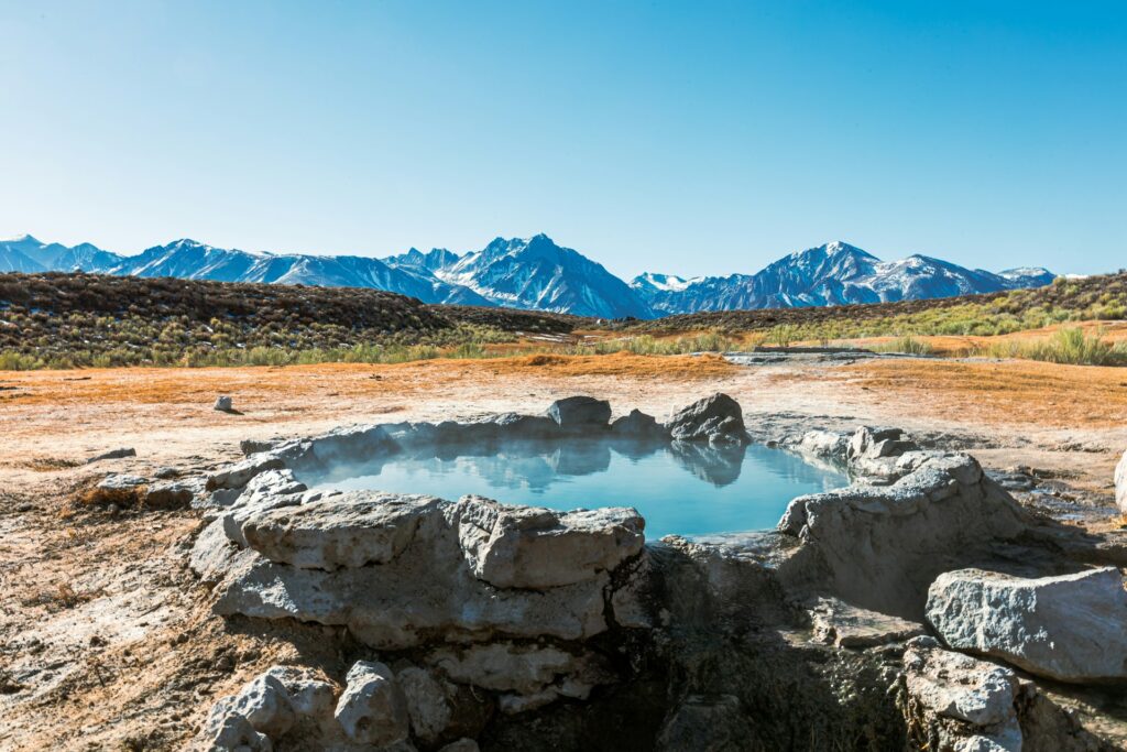 A hot spring with a mountain range in the background. 