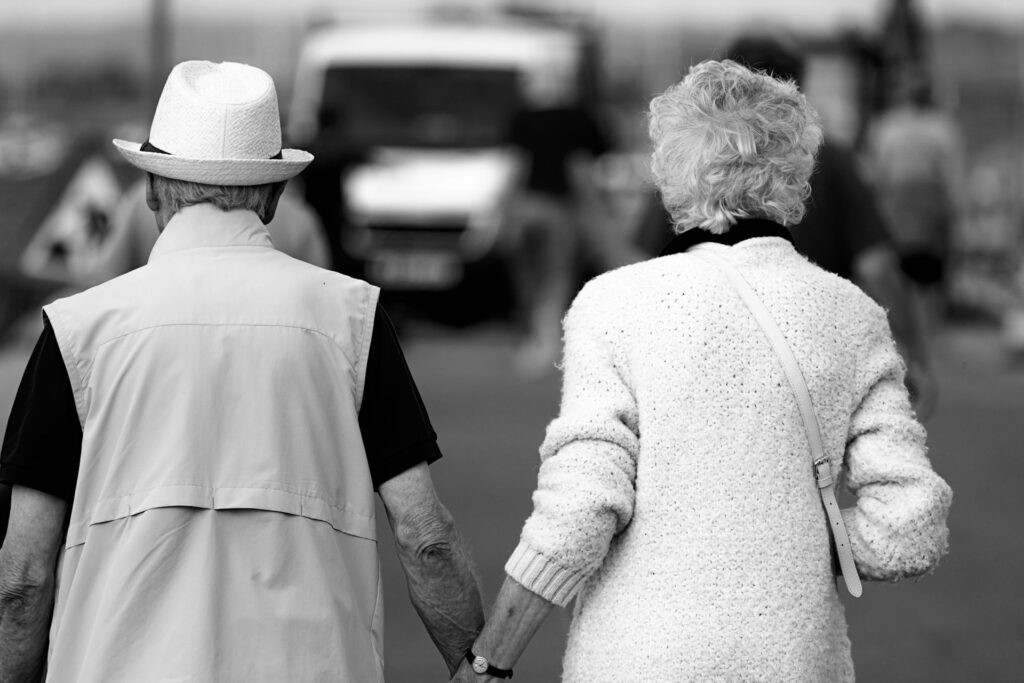 An elderly couple holding hands.