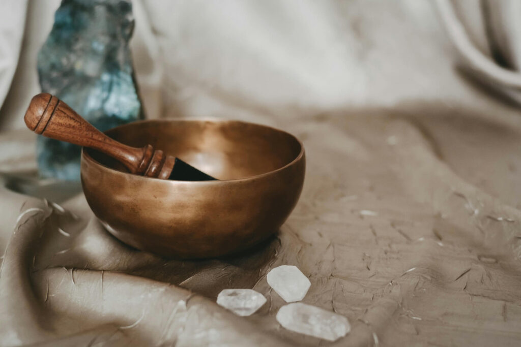 A Himalayan singing bowl next to some crystals