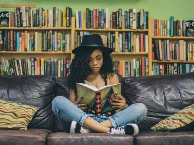 Woman reading a book in front of a bookcase