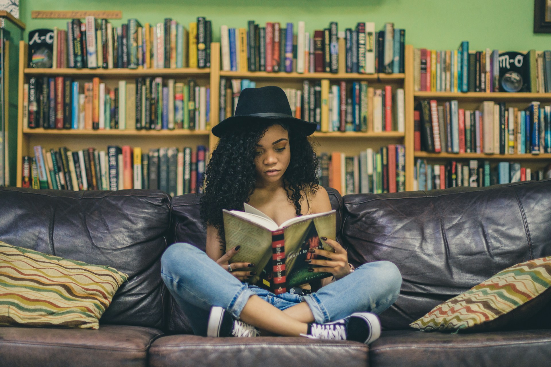 Woman reading a book in front of a bookcase